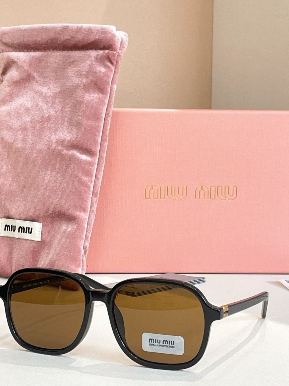 Miu Miu Black Frame Sunglasses with Brown Lenses and Pink Accessories